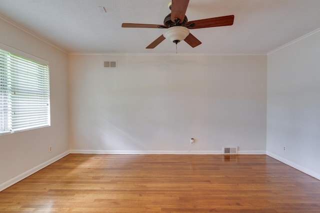 unfurnished room with visible vents, light wood-style floors, and crown molding