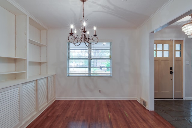 unfurnished dining area with an inviting chandelier, ornamental molding, wood finished floors, and visible vents