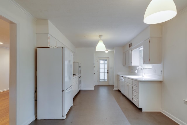 kitchen with baseboards, freestanding refrigerator, white cabinetry, and light countertops