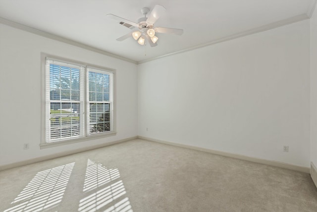 spare room with a ceiling fan, ornamental molding, and light carpet
