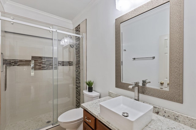 bathroom with crown molding, vanity, a shower stall, and toilet