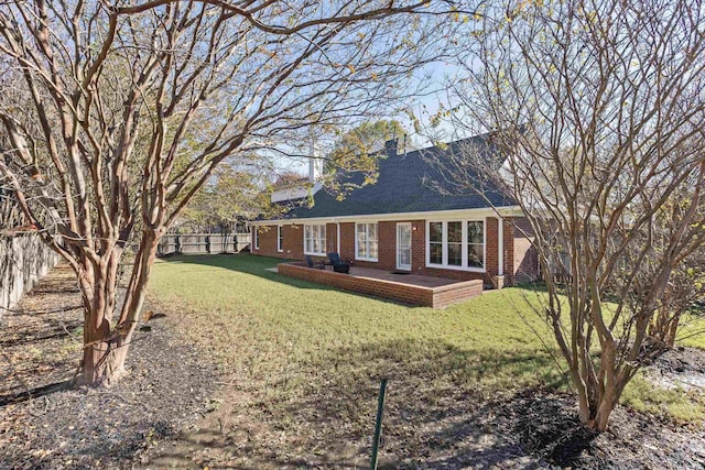 view of front of house with brick siding, fence, and a front yard