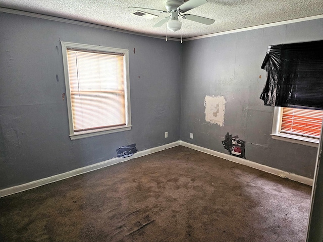 carpeted empty room featuring ornamental molding, a ceiling fan, and a textured ceiling