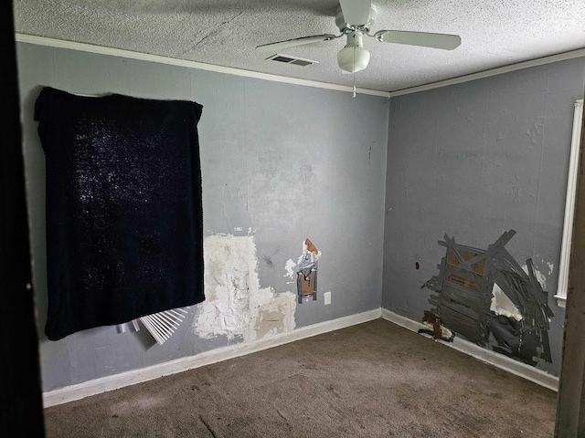 carpeted empty room with ceiling fan, ornamental molding, a textured ceiling, and visible vents