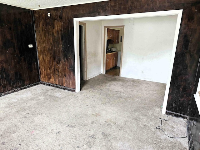 unfurnished room featuring carpet flooring and wood walls