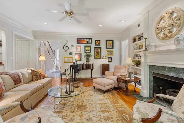 living room with crown molding, ceiling fan, wood finished floors, and stairway