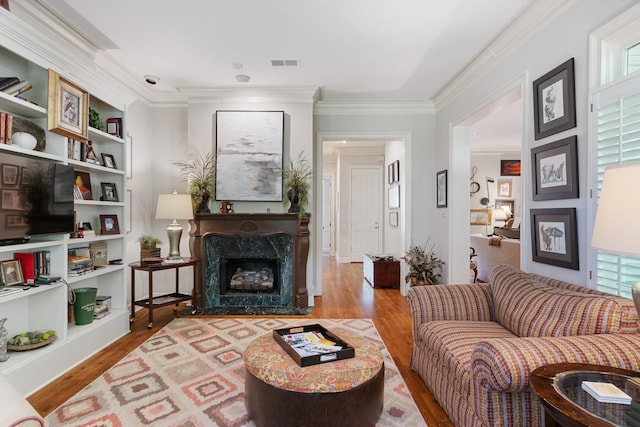 living room featuring ornamental molding, wood finished floors, and visible vents
