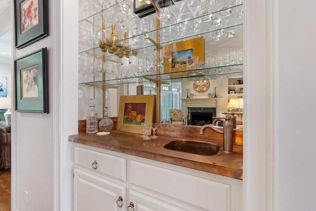 bar featuring bar, a sink, and a fireplace