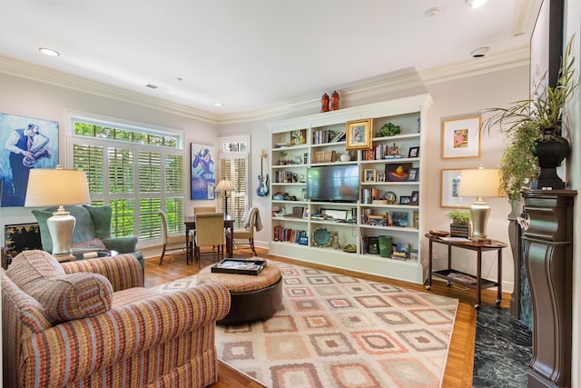 living area featuring visible vents, ornamental molding, and wood finished floors