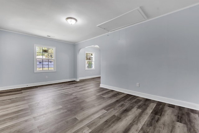 unfurnished room with crown molding, baseboards, visible vents, and attic access