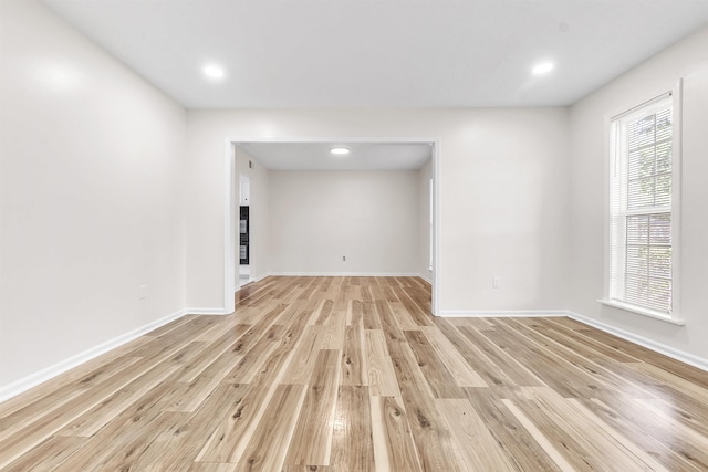 spare room with recessed lighting, baseboards, and light wood-type flooring