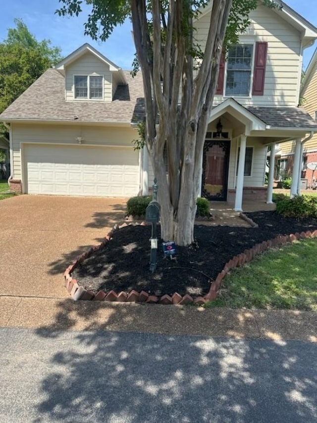view of front of home with brick siding, a shingled roof, covered porch, and concrete driveway
