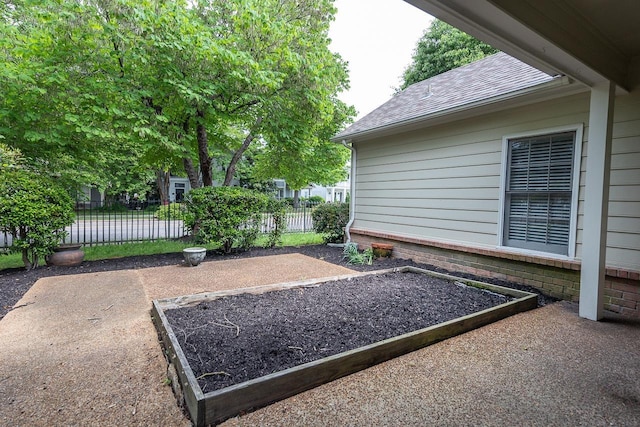 view of yard featuring fence and a garden