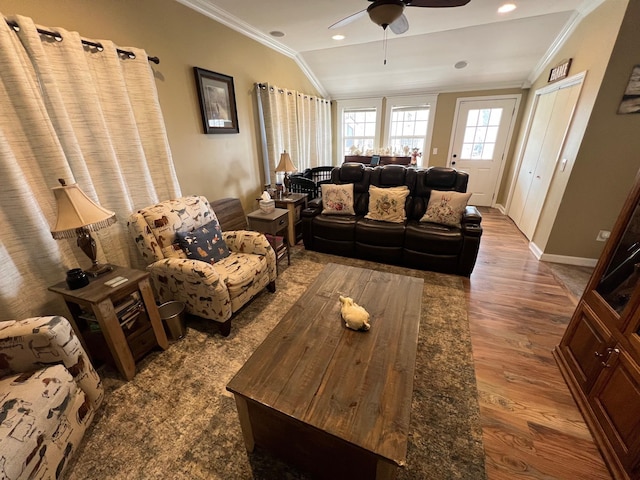 living area featuring crown molding, a ceiling fan, baseboards, wood finished floors, and lofted ceiling