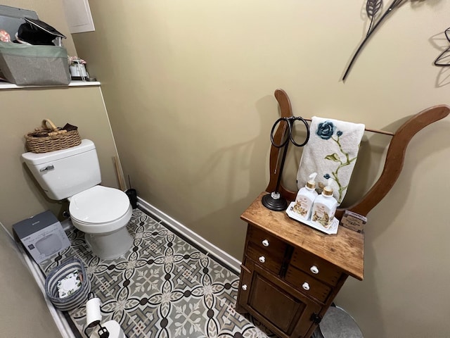 bathroom featuring baseboards, tile patterned floors, and toilet