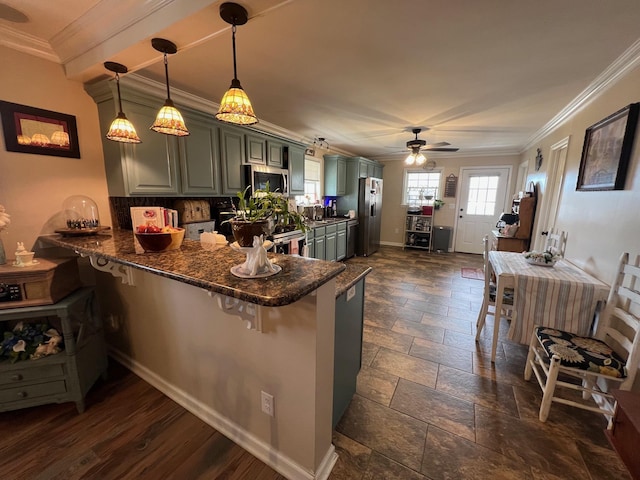 kitchen with crown molding, stone tile floors, a peninsula, ceiling fan, and appliances with stainless steel finishes