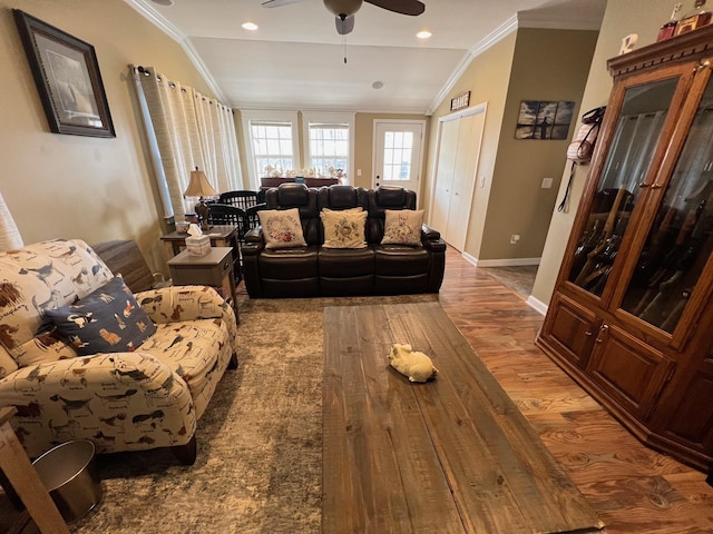 living room featuring a ceiling fan, baseboards, wood finished floors, vaulted ceiling, and ornamental molding