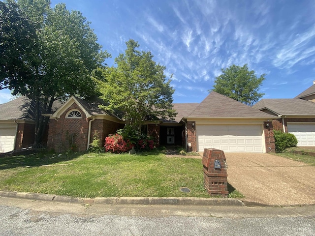 single story home with a garage, a front yard, driveway, and brick siding