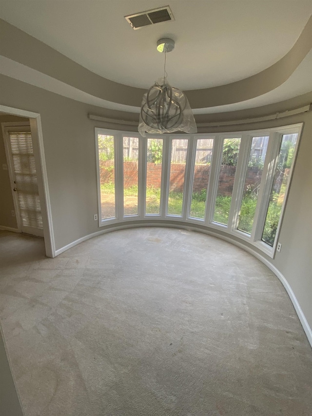 unfurnished dining area with an inviting chandelier, carpet floors, baseboards, and visible vents