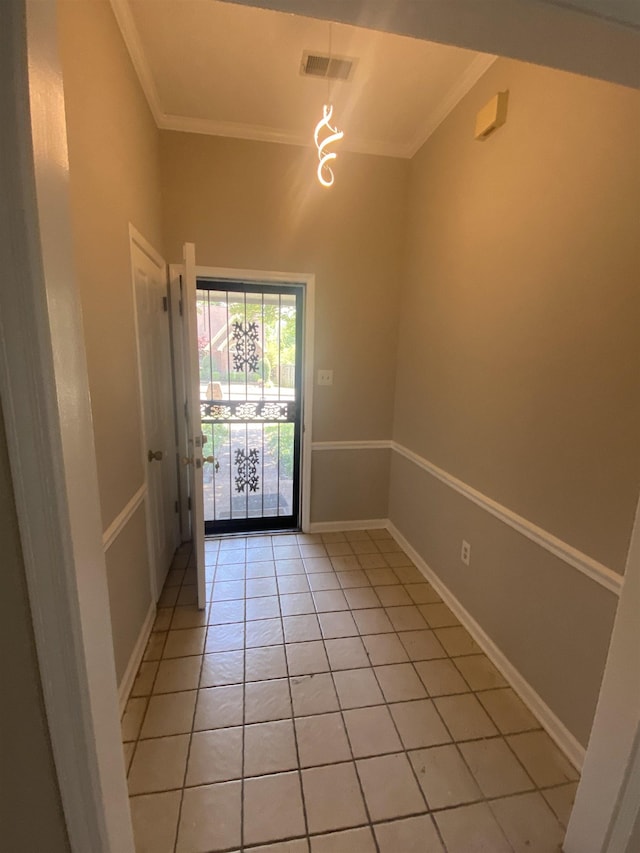 doorway to outside with crown molding, baseboards, visible vents, and light tile patterned floors