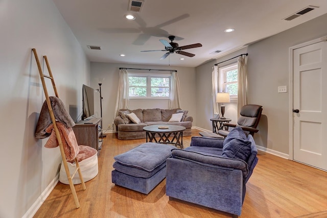 living area featuring a ceiling fan, visible vents, and plenty of natural light