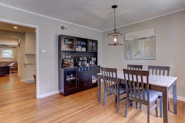 dining room featuring visible vents, baseboards, and light wood-type flooring