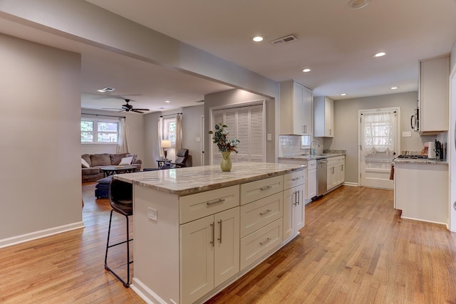kitchen with a ceiling fan, light wood-style floors, white cabinetry, a sink, and stainless steel appliances