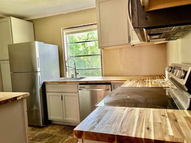 kitchen with a sink, stainless steel appliances, and wooden counters