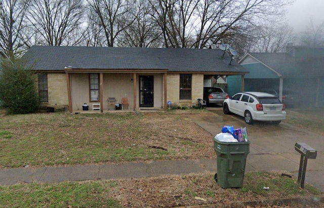 single story home with brick siding, driveway, and a carport