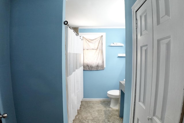 full bathroom featuring baseboards, vanity, and toilet