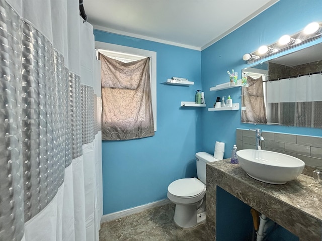 full bathroom featuring ornamental molding, toilet, a shower with curtain, a sink, and backsplash