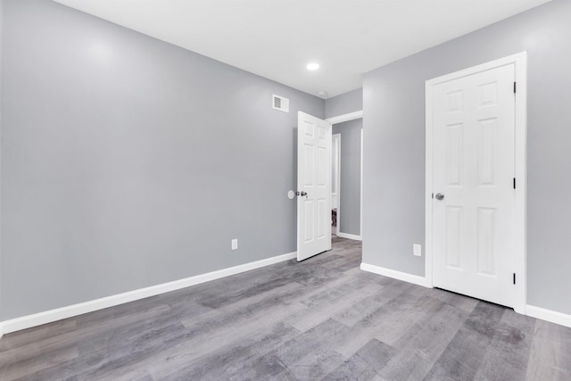 unfurnished bedroom featuring recessed lighting, baseboards, visible vents, and wood finished floors