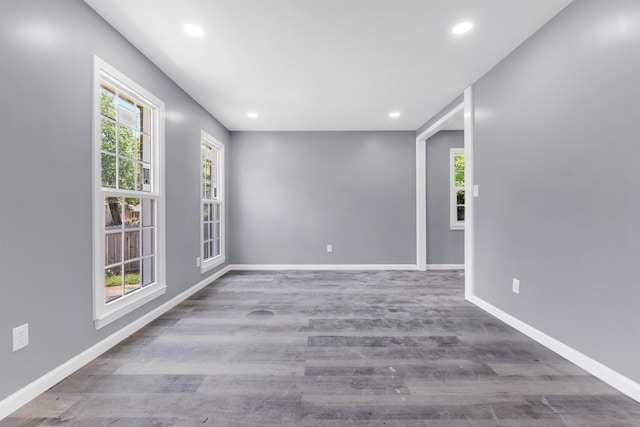 spare room featuring recessed lighting, baseboards, and wood finished floors