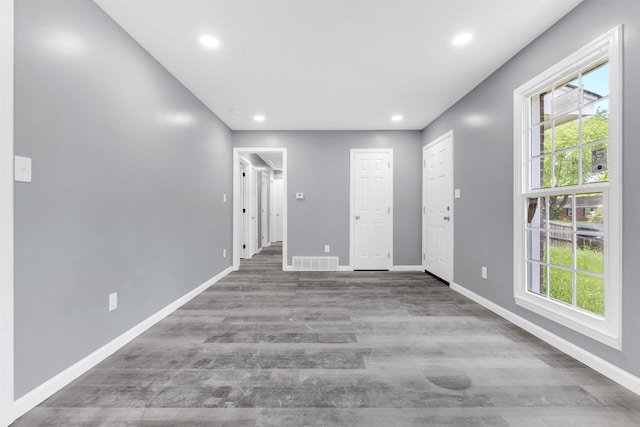 spare room with baseboards, visible vents, a wealth of natural light, and wood finished floors