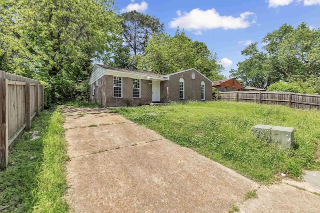 exterior space featuring brick siding, fence, and concrete driveway