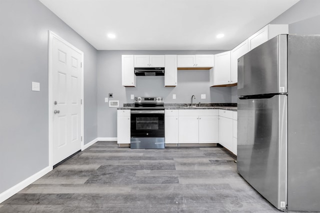 kitchen featuring white cabinets, range hood, and stainless steel appliances