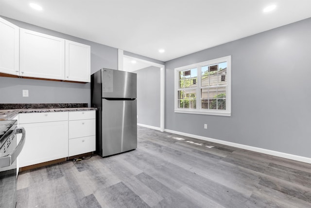 kitchen with baseboards, white cabinets, freestanding refrigerator, light wood-style floors, and recessed lighting