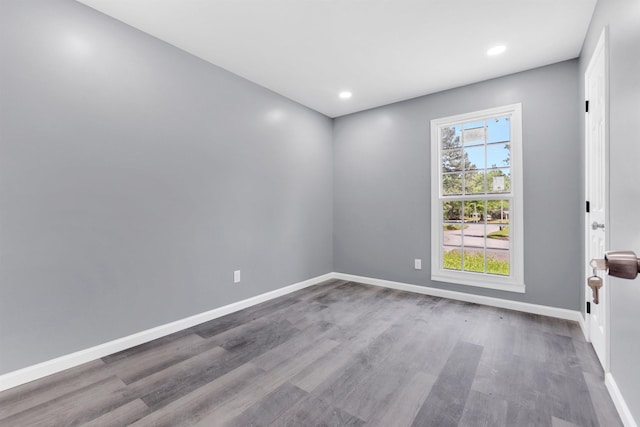 spare room with recessed lighting, baseboards, and wood finished floors