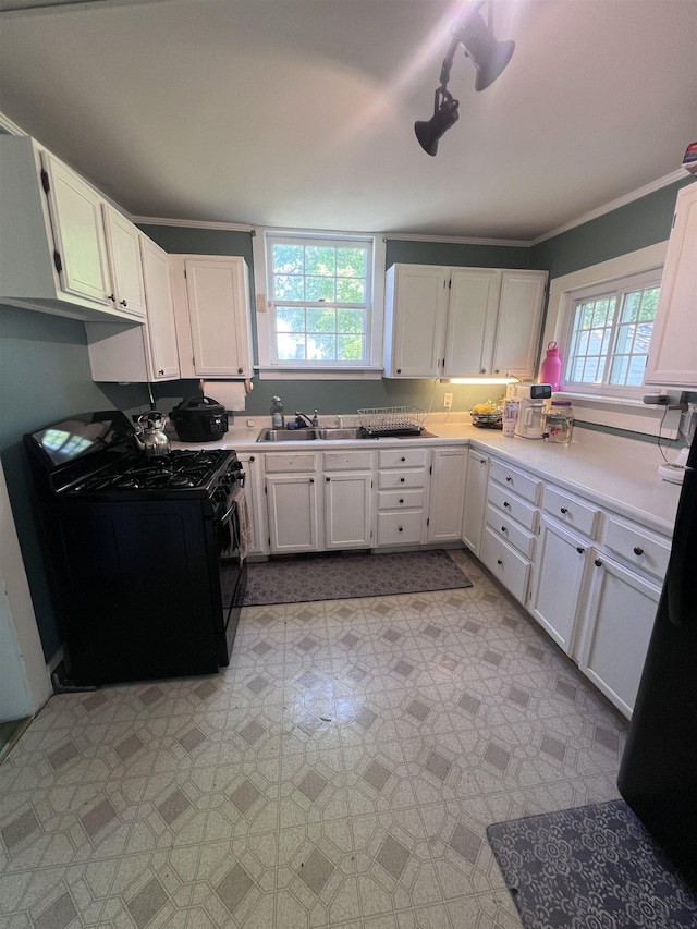 110 Shelton St, Covington, TN 38019 - kitchen featuring crown molding, light floors, white cabinets, a sink, and gas stove