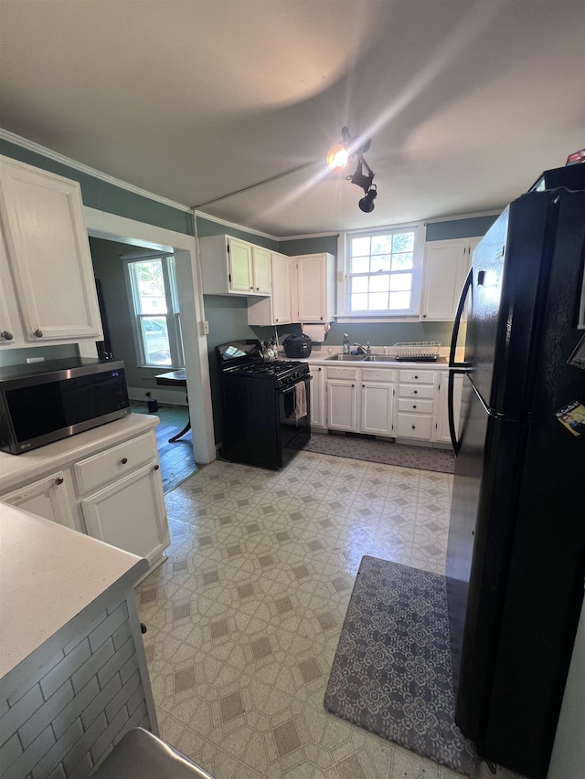 110 Shelton St, Covington, TN 38019 - kitchen with a healthy amount of sunlight, black appliances, and light floors