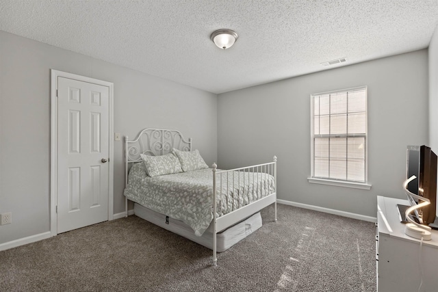 bedroom featuring baseboards, a textured ceiling, and carpet