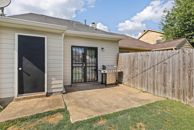 back of property featuring fence, a chimney, and a patio area