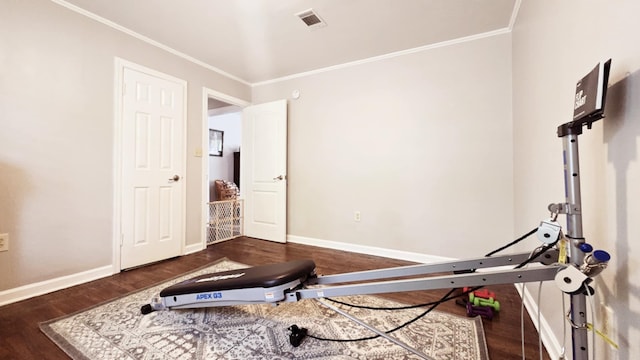 workout area with crown molding, baseboards, and wood finished floors