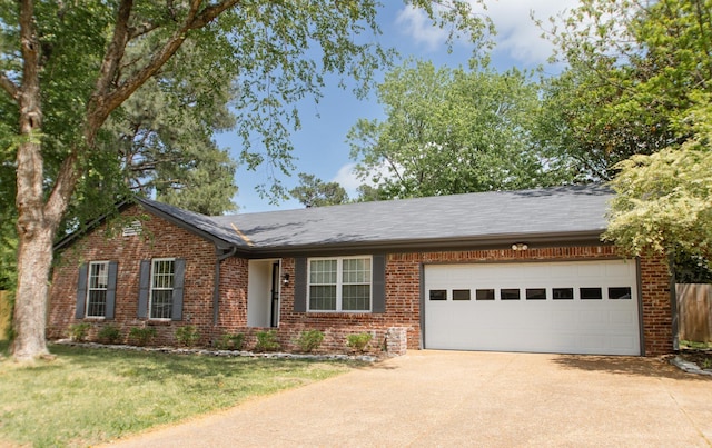 ranch-style home with concrete driveway, brick siding, a front yard, and a garage