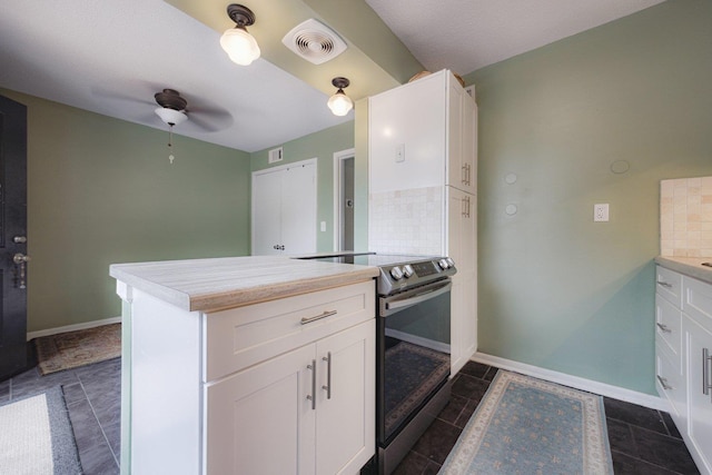 kitchen featuring a peninsula, tasteful backsplash, electric range, and visible vents