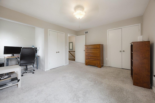 carpeted office featuring baseboards and visible vents