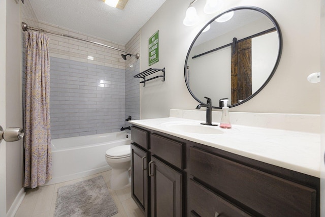 full bath with tile patterned flooring, shower / bath combo, vanity, toilet, and a textured ceiling