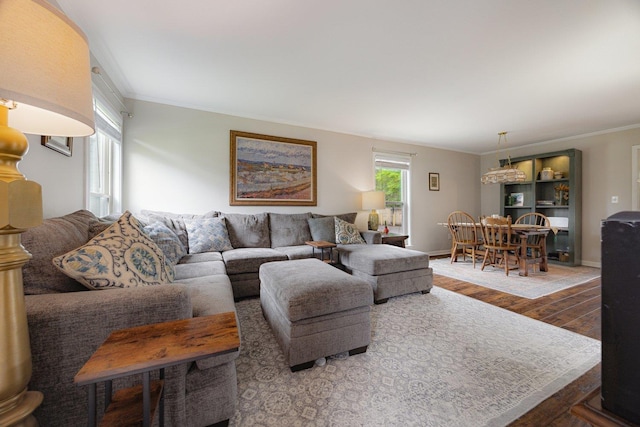 living room featuring crown molding, baseboards, and hardwood / wood-style floors