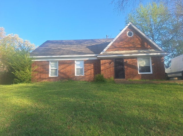 view of front facade with brick siding and a front lawn
