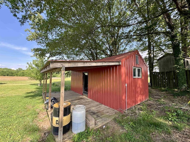 view of outbuilding featuring fence and an outdoor structure